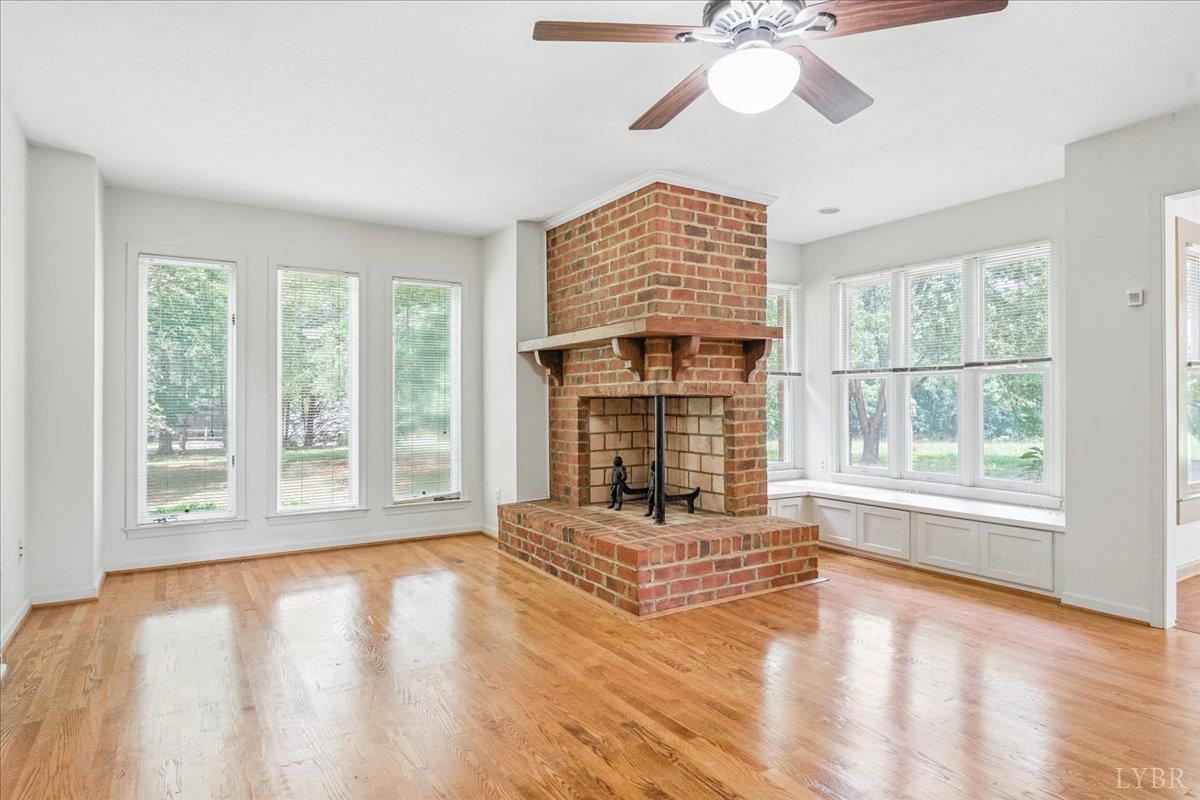 530 Patteson School Road Appomattox, VA 24522 - Photo 8 of 45 a living room with a fireplace furniture a ceiling fan and a large window