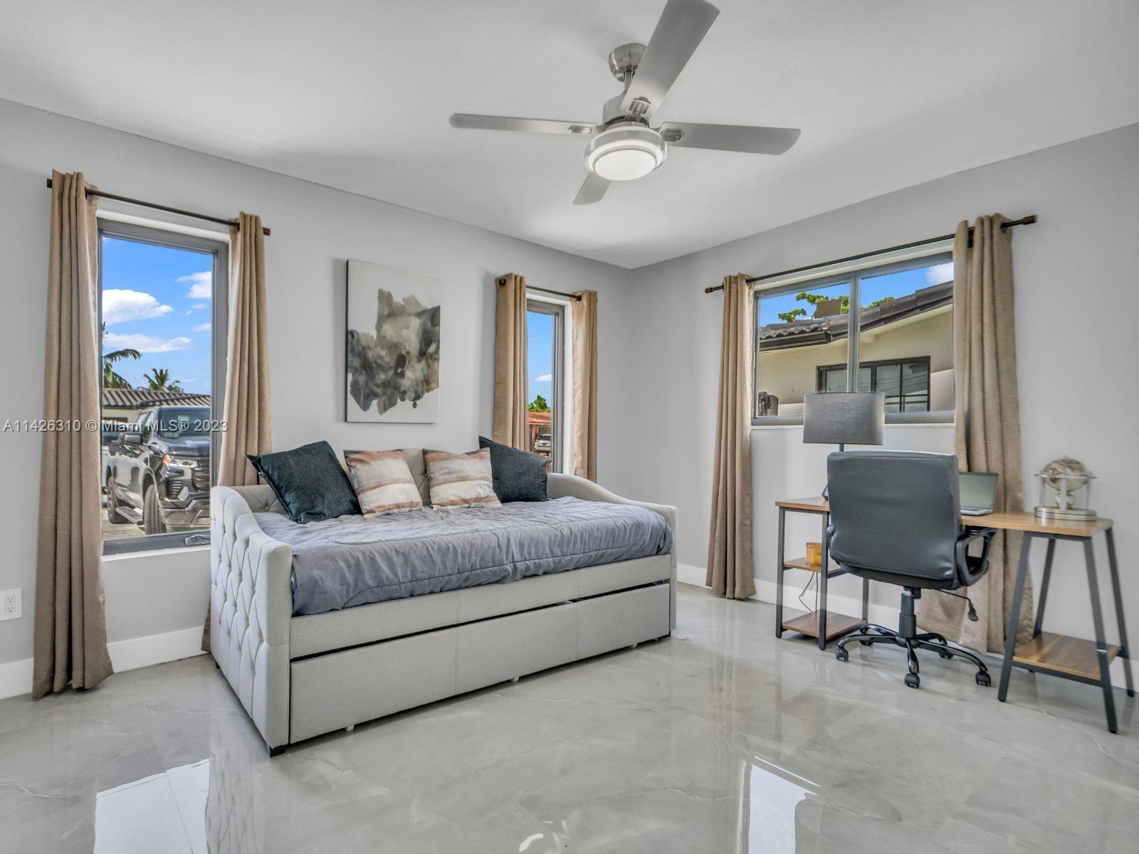 9670 Southwest 17th Street Miami, FL 33165 - Photo 13 of 17 a spacious bedroom with a bed a table and chair