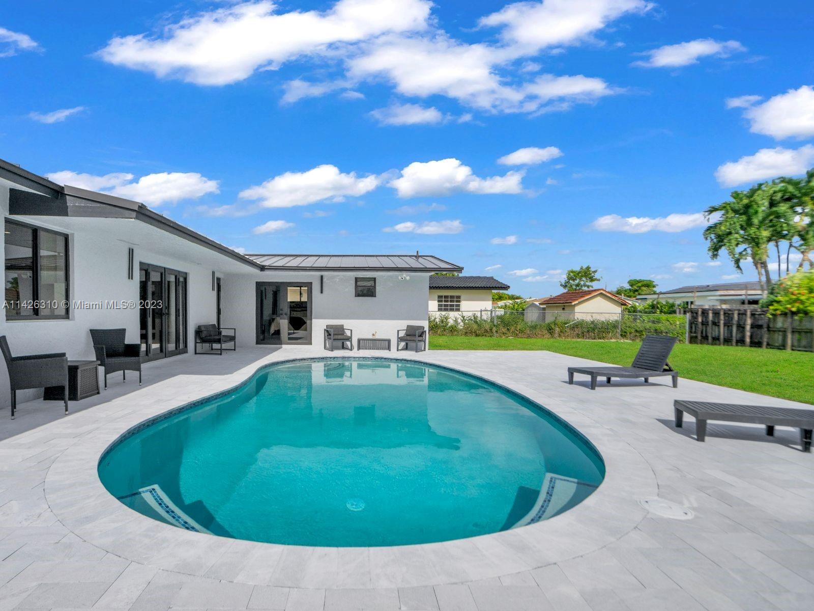 9670 Southwest 17th Street Miami, FL 33165 - Photo 2 of 17 a swimming pool with outdoor seating and yard