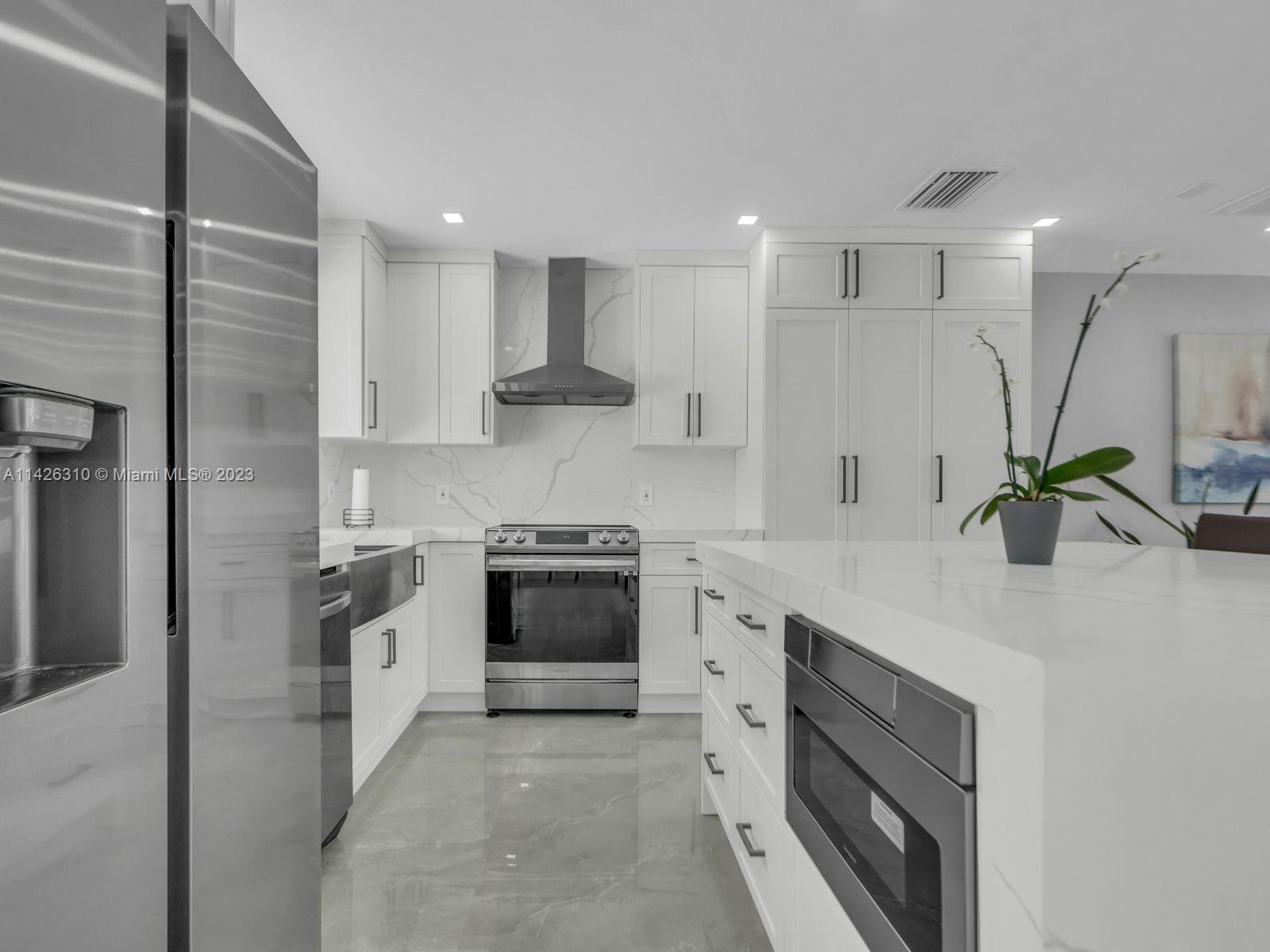 9670 Southwest 17th Street Miami, FL 33165 - Photo 6 of 17 a kitchen with stainless steel appliances kitchen island granite countertop a sink a stove and a refrigerator