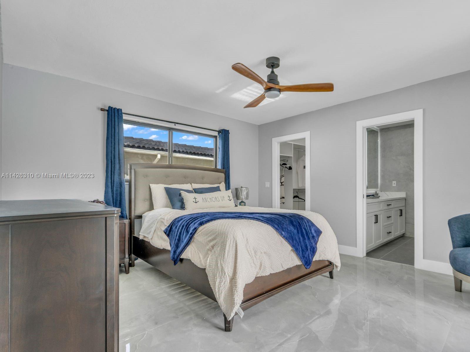 9670 Southwest 17th Street Miami, FL 33165 - Photo 10 of 17 a bed sitting in a bedroom next to a window