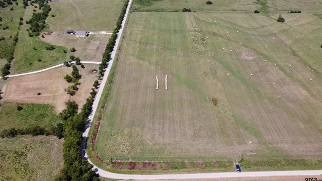 an aerial view of field with trees