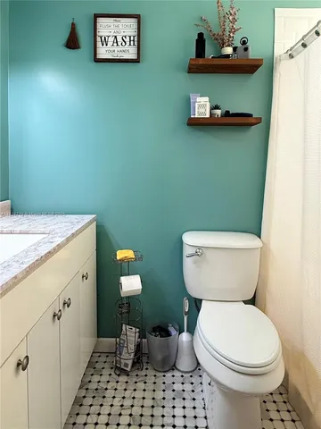 a bathroom with a toilet a sink and a mirror