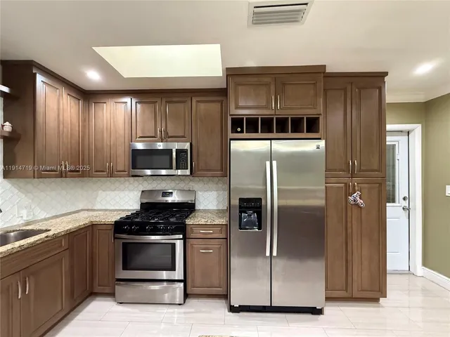 a kitchen with granite countertop a refrigerator and a stove