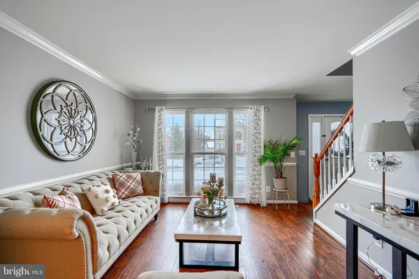 a living room with furniture a wooden floor and a large window