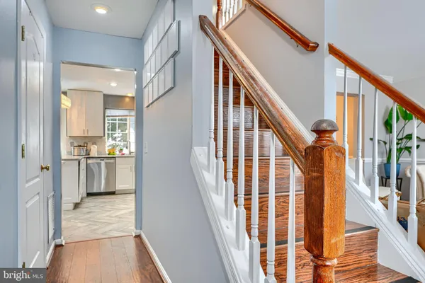 a view of a hallway with wooden floor and staircase