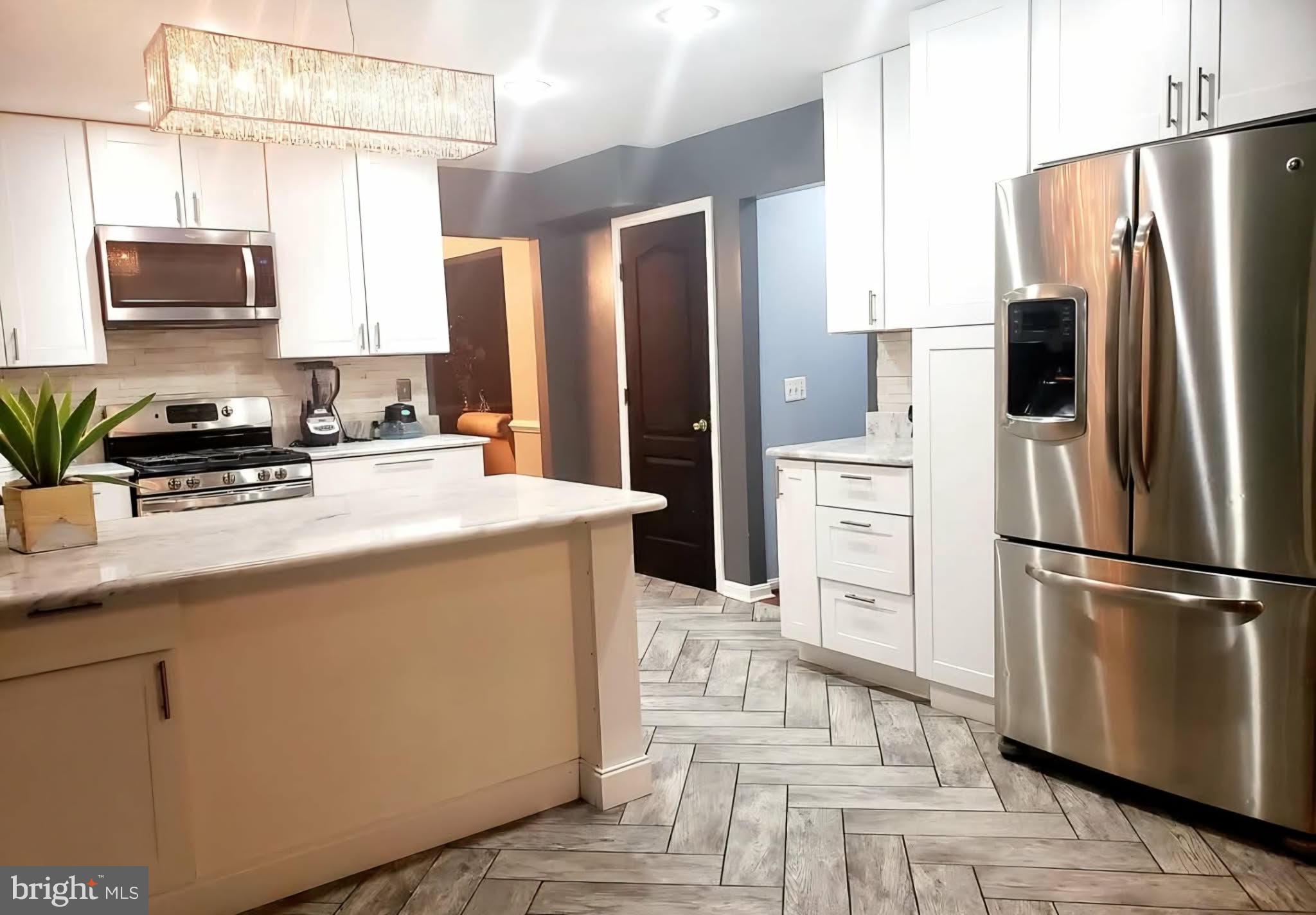 8113 Alan Tree Road Rosedale, MD 21237 - Photo 7 of 13 a kitchen with stainless steel appliances a refrigerator stove microwave and sink