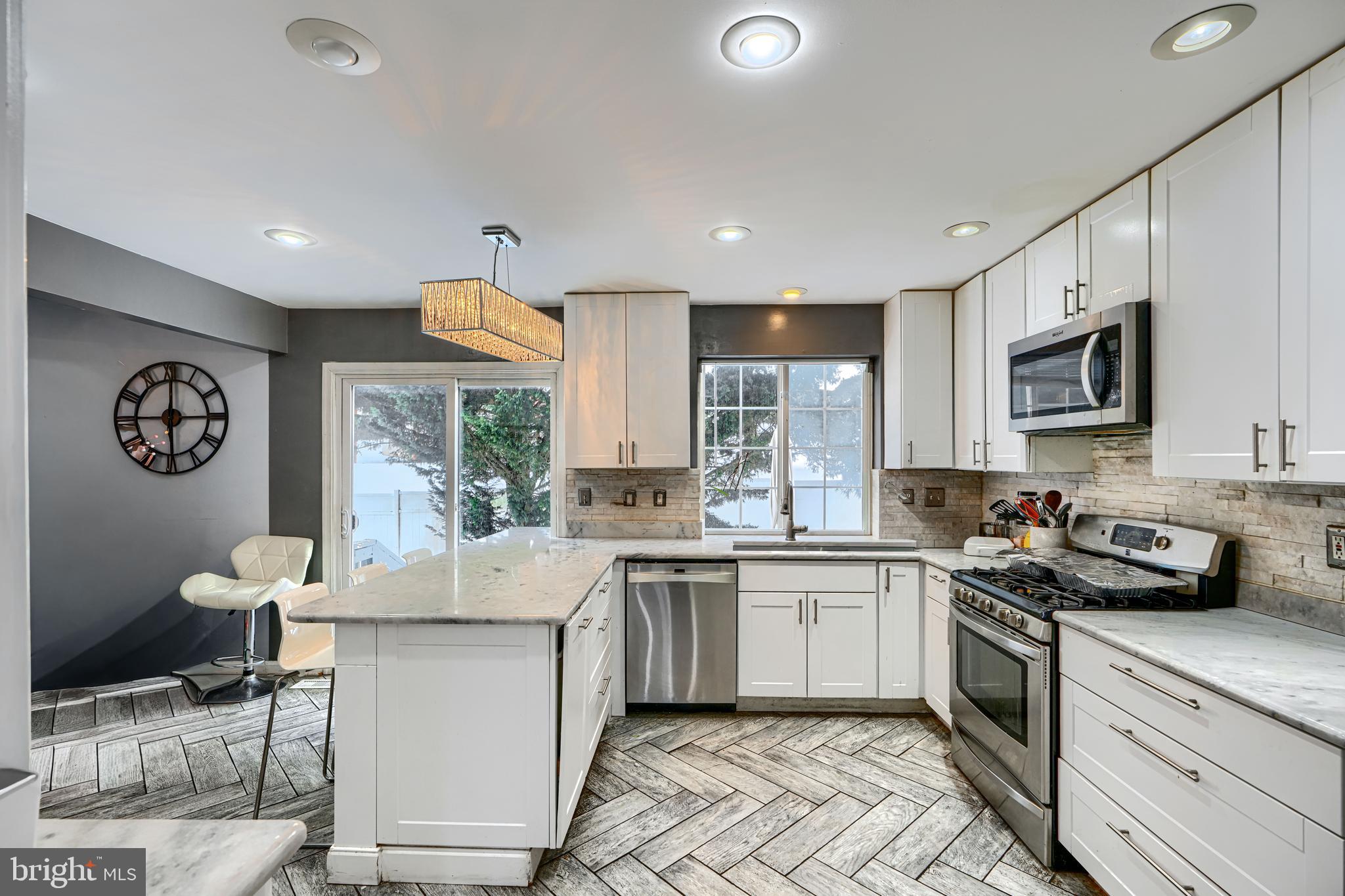 8113 Alan Tree Road Rosedale, MD 21237 - Photo 7 of 16 a kitchen with stainless steel appliances granite countertop a sink a stove a refrigerator cabinets and a window