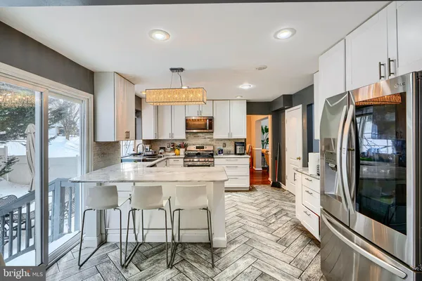 a kitchen with stainless steel appliances kitchen island granite countertop a refrigerator and a stove top oven