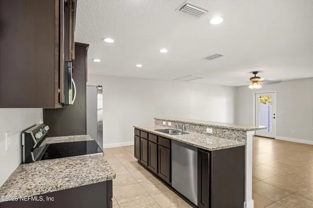 a kitchen with stainless steel appliances granite countertop a stove a sink and a refrigerator