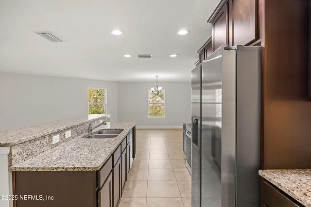 a bathroom with a granite countertop sink a refrigerator and window
