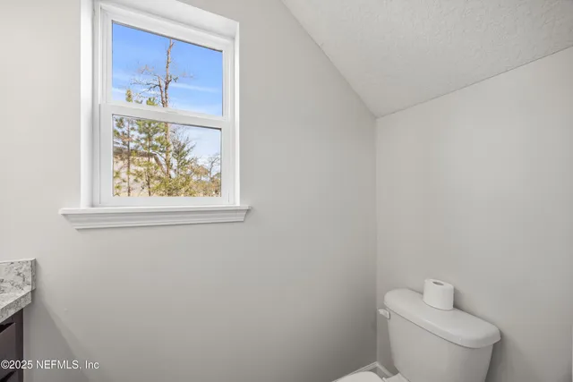a white toilet sitting next to a window