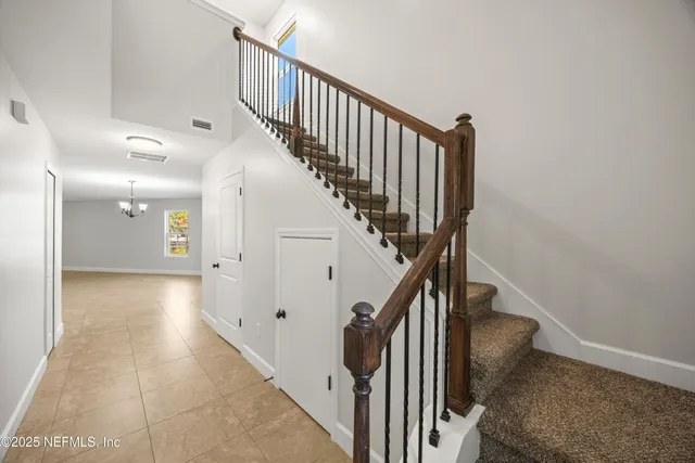a view of a hallway with wooden floor and stairs