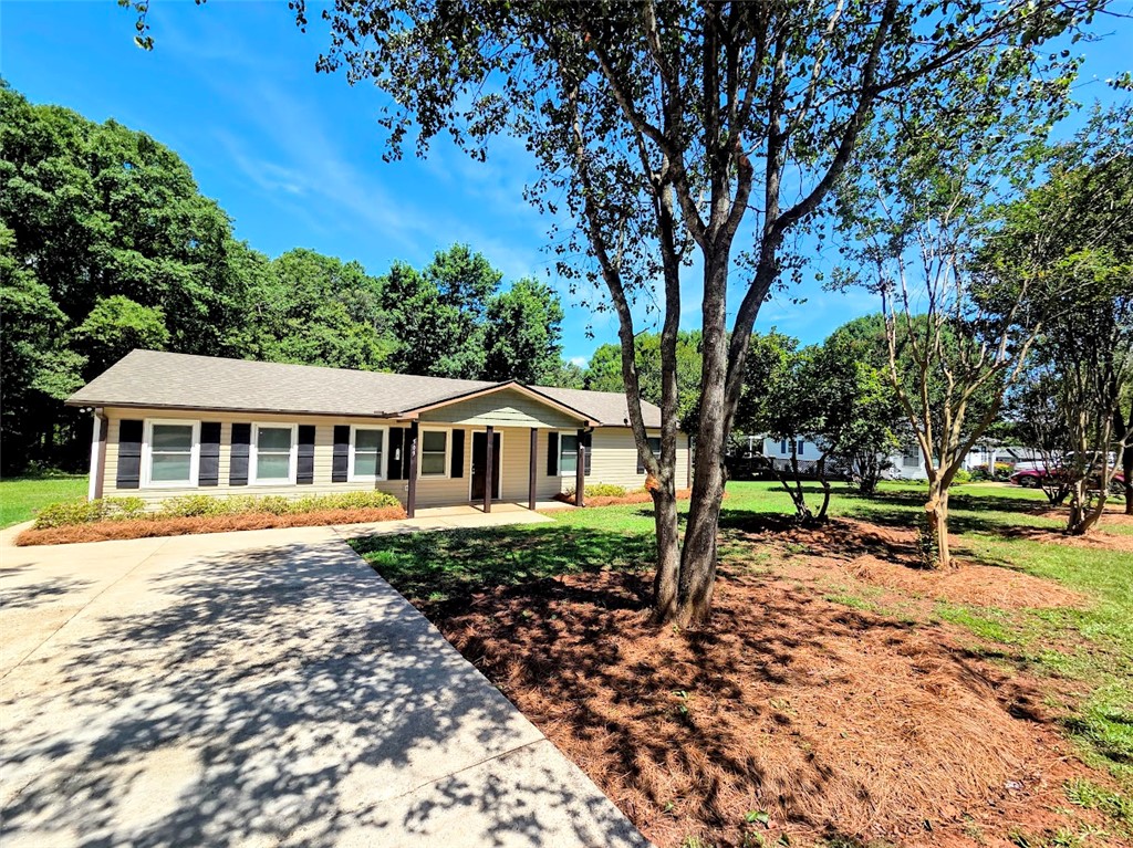 509 Elrod Road Piedmont, SC 29673 - Photo 2 of 28 A welcoming facade with a covered entry and mature trees framing the well-maintained lawn.