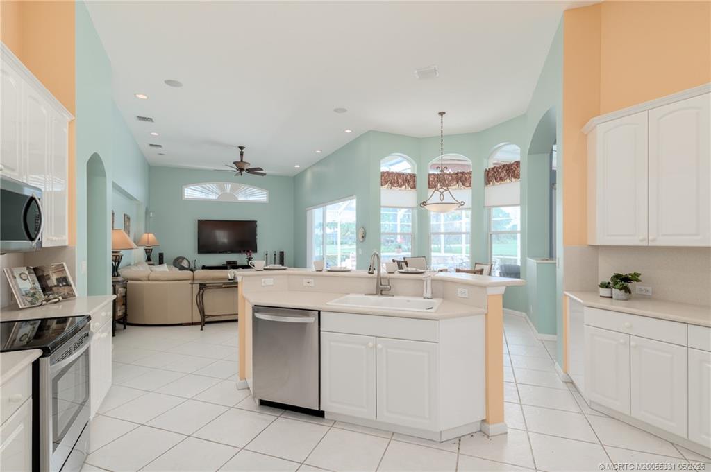 2216 Southeast Stonehaven Road Port St. Lucie, FL 34952 - Photo 13 of 67 a large white kitchen with a sink and cabinets