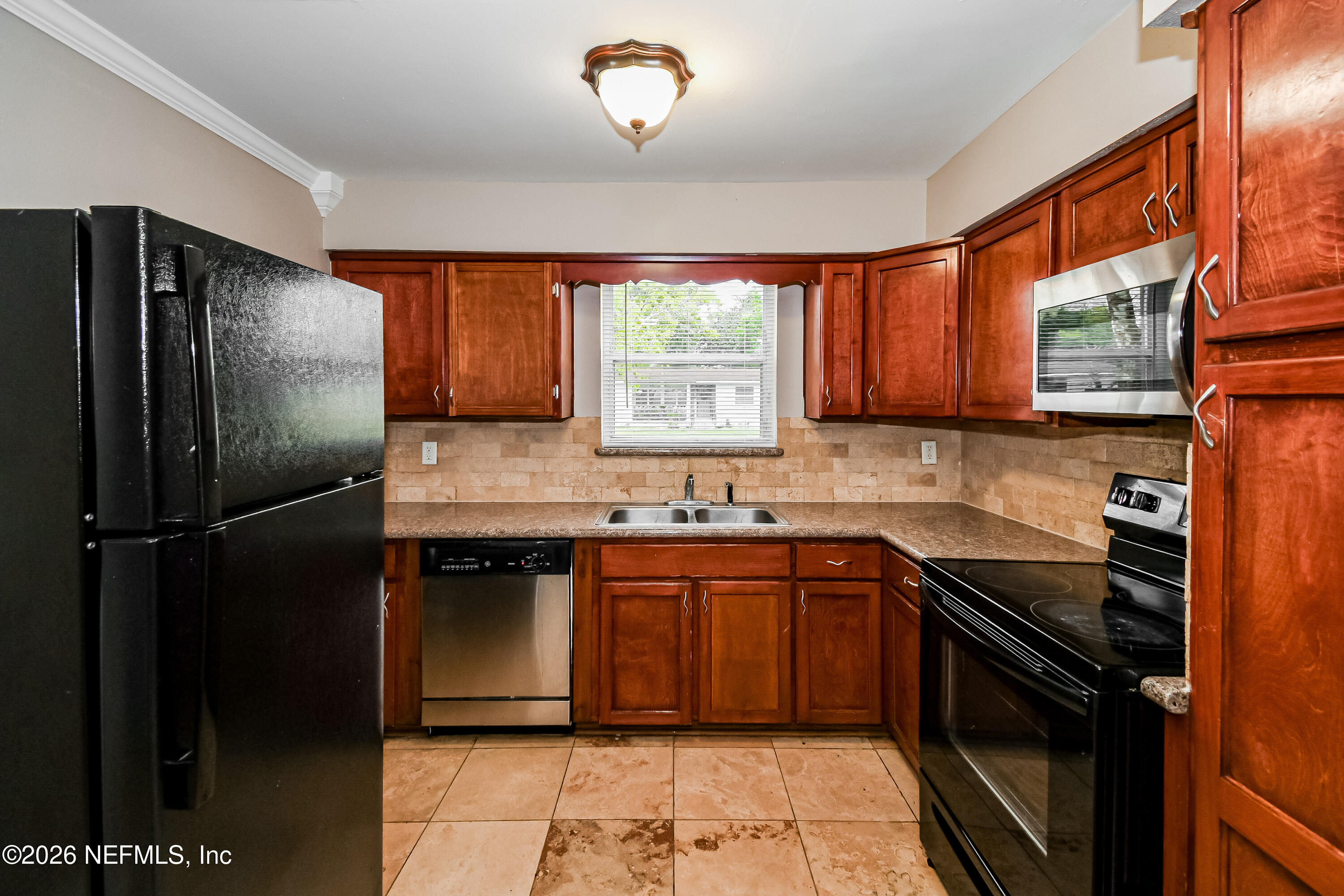 7227 Stonehurst Road North Jacksonville, FL 32277 - Photo 6 of 16 a kitchen with a sink a refrigerator and window