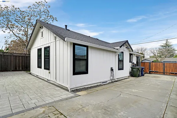 a kitchen with stainless steel appliances granite countertop a refrigerator a stove a sink dishwasher and white cabinets with wooden floor