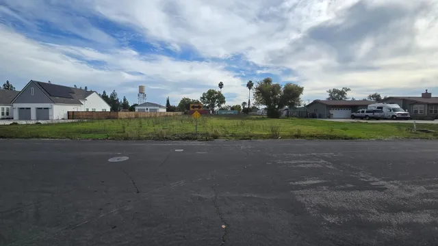 a view of a big house with a big yard and a large tree