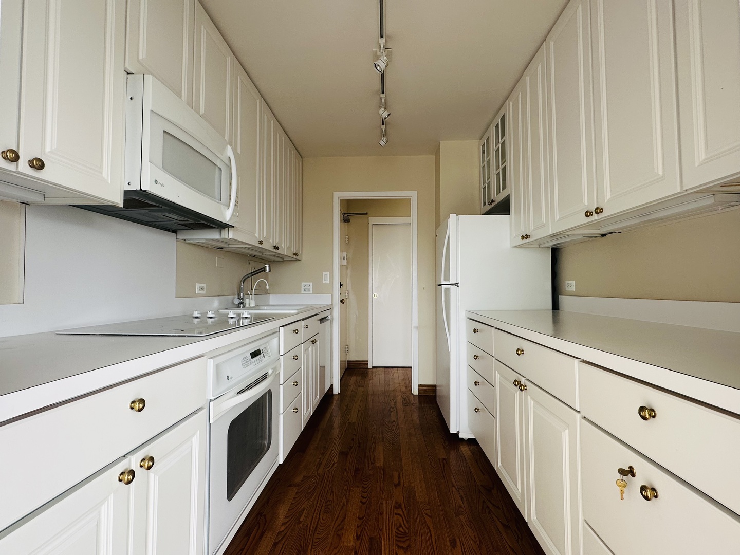 5757 North Sheridan Road, Unit 17H Chicago, IL 60660 - Photo 9 of 25 a kitchen with granite countertop white cabinets and white appliances