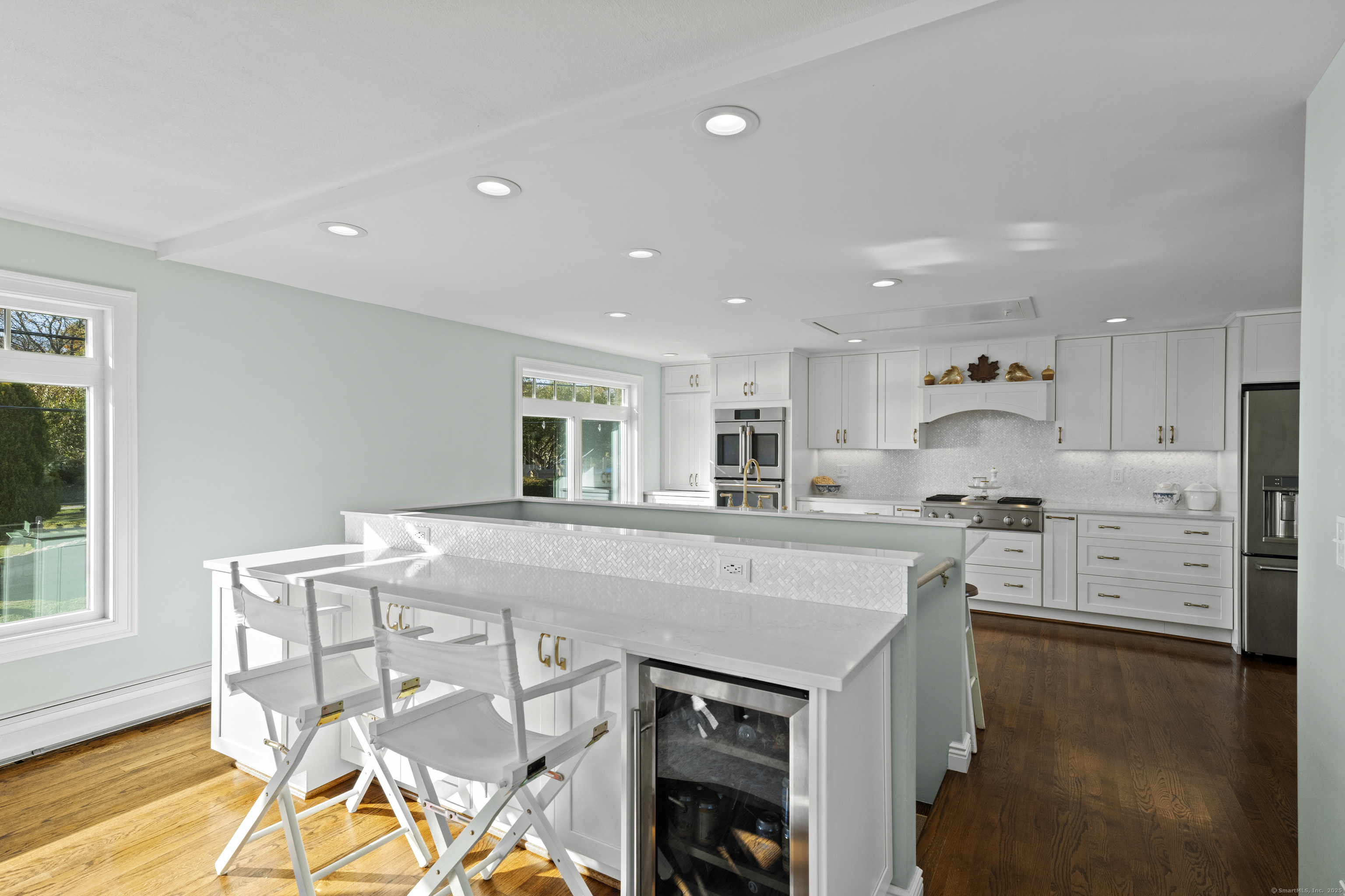 21 Harbor Street Branford, CT 06405 - Photo 14 of 40 a kitchen with stainless steel appliances granite countertop a stove a sink a microwave a dining table and chairs with wooden floor