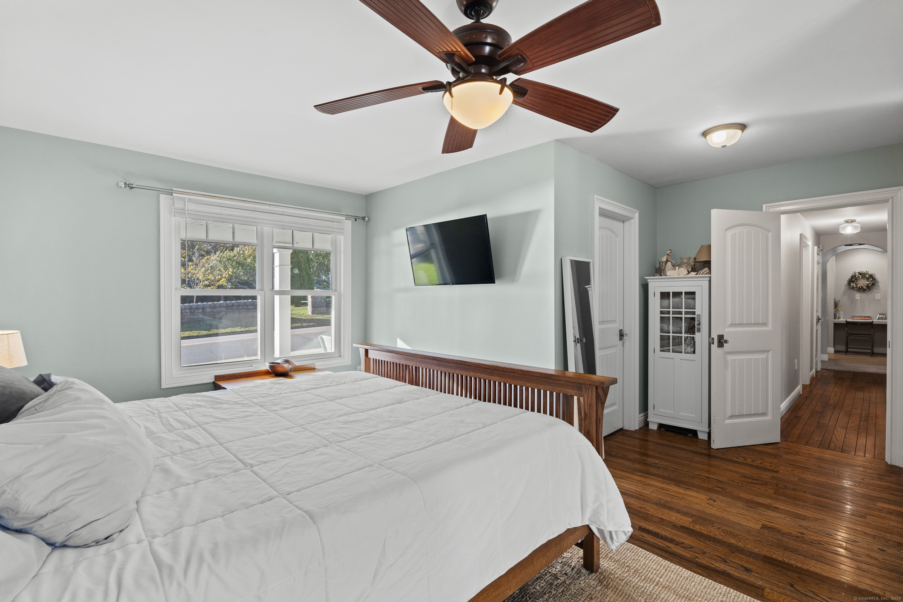 21 Harbor Street Branford, CT 06405 - Photo 21 of 40 a bedroom with a bed and a large mirror with wooden floor