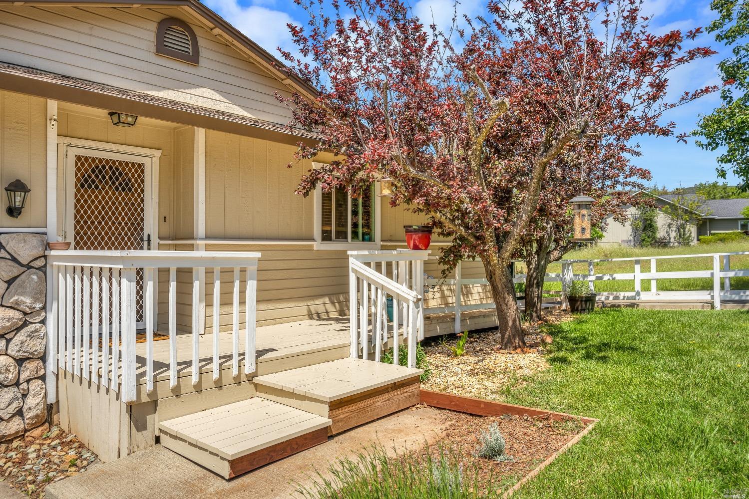 a view of a house with a small yard and deck