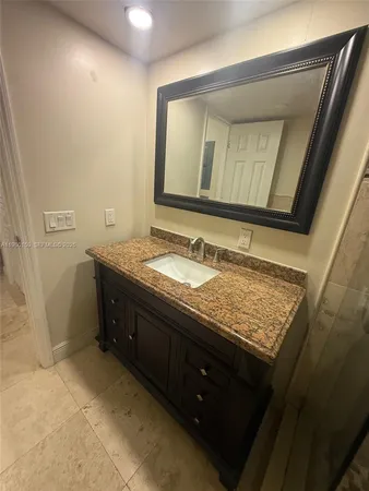 a bathroom with a granite countertop sink and a mirror