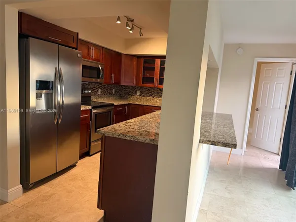 a kitchen with stainless steel appliances granite countertop a refrigerator and a sink