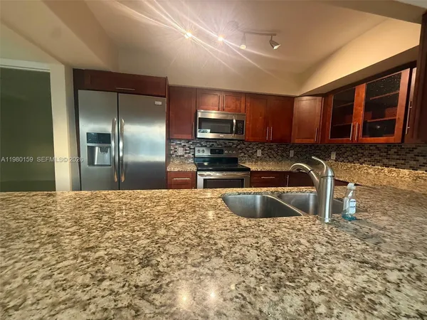 a kitchen with stainless steel appliances granite countertop a sink stove and granite counter top