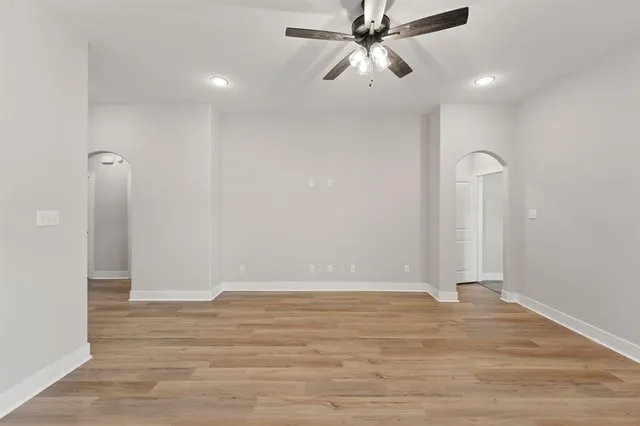 a view of a room with wooden floor and ceiling fan