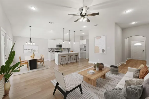 a living room with furniture kitchen view and a chandelier