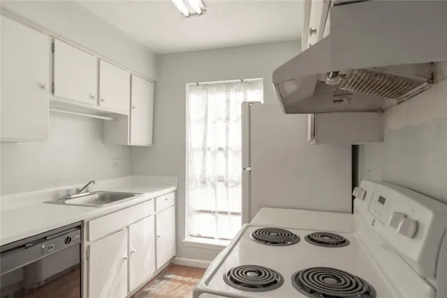 a kitchen with a sink a stove and a refrigerator