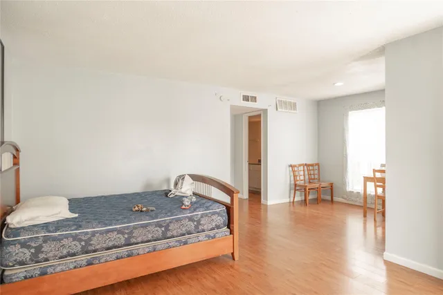 a bedroom with a bed and wooden floor