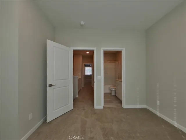 an empty room with closet and a bathroom