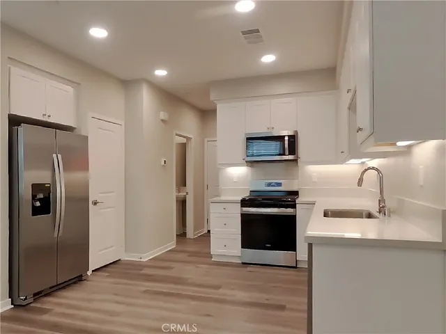 a kitchen with stainless steel appliances granite countertop a refrigerator stove and sink