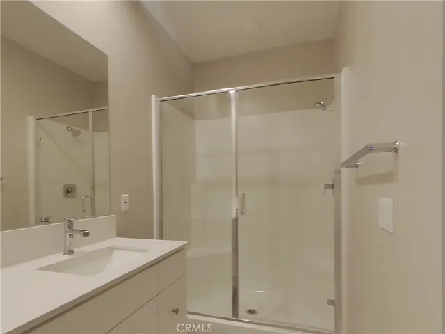 a bathroom with a shower sink vanity and mirror