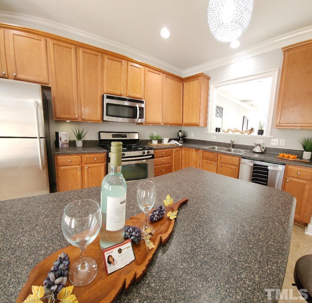 7738 ACC Boulevard Raleigh, NC 27617 - Photo 2 of 17 a kitchen with stainless steel appliances granite countertop a sink a stove counter space and a refrigerator