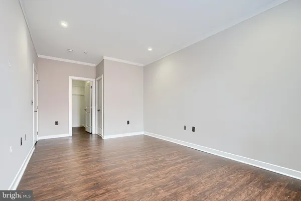 a view of an empty room with wooden floor