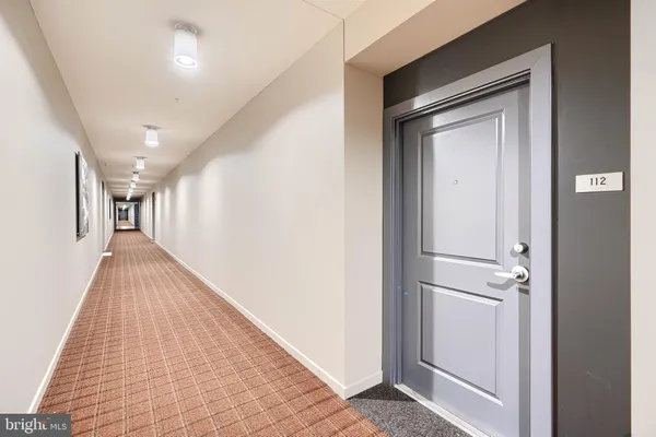 a view of a hallway with closet and wooden floor