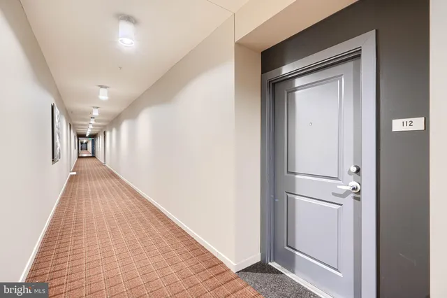 a view of a hallway with closet and wooden floor