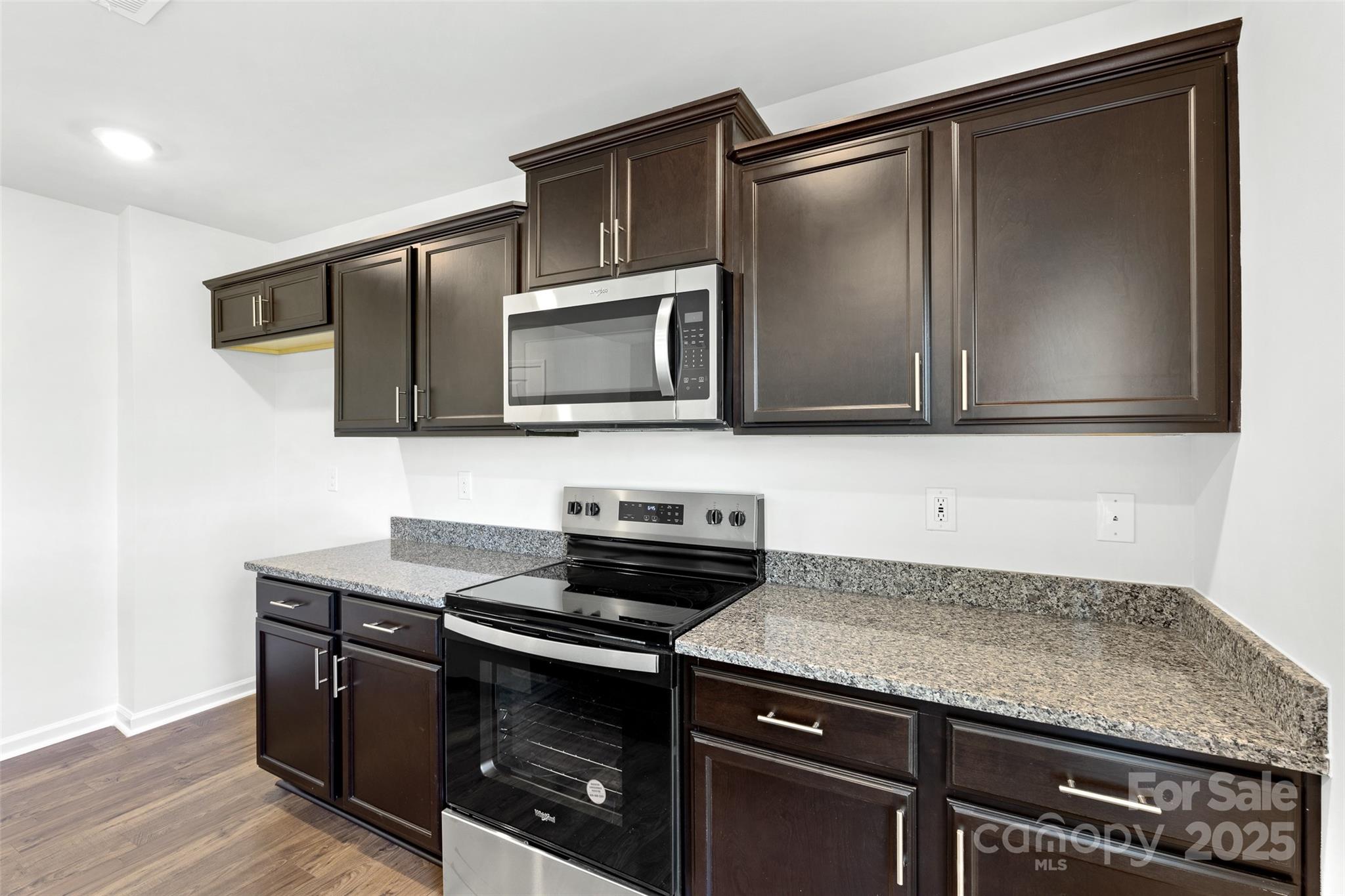 205 Callie River Clyde, NC 28721 - Photo 4 of 20 a kitchen with granite countertop a stove microwave and sink