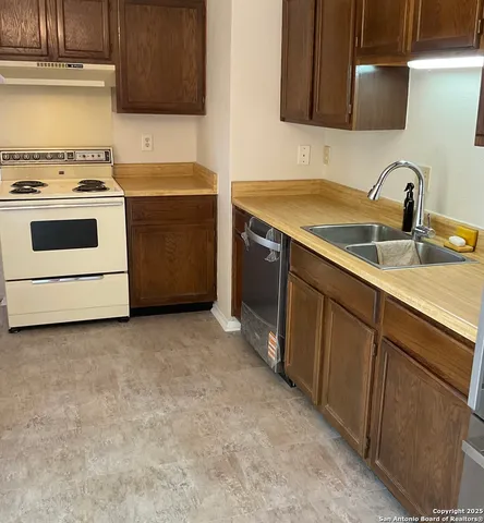 a kitchen with a sink stove and cabinets