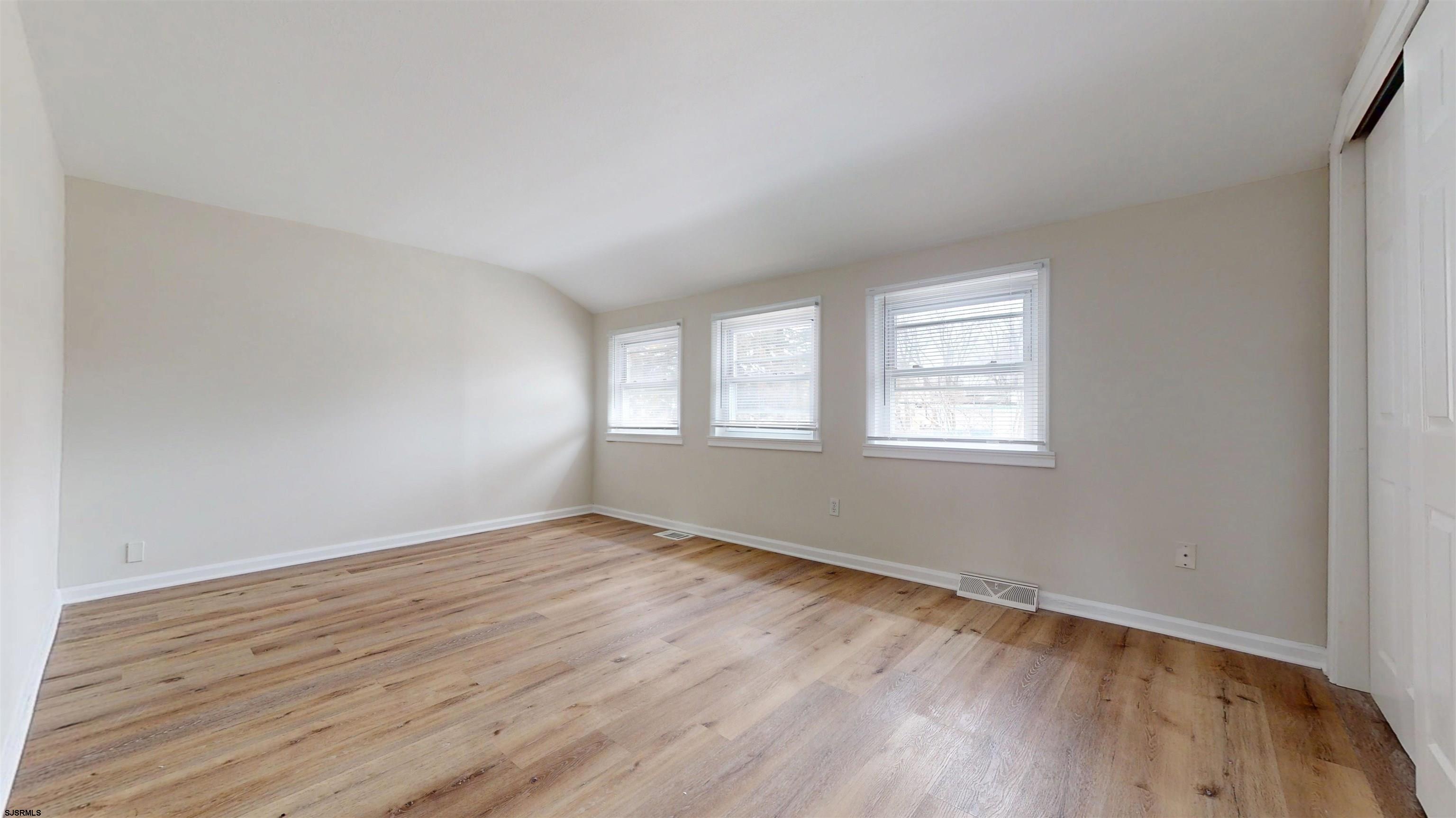 4 East Mill Road Northfield, NJ 08225 - Photo 24 of 49 a view of an empty room with wooden floor and a window
