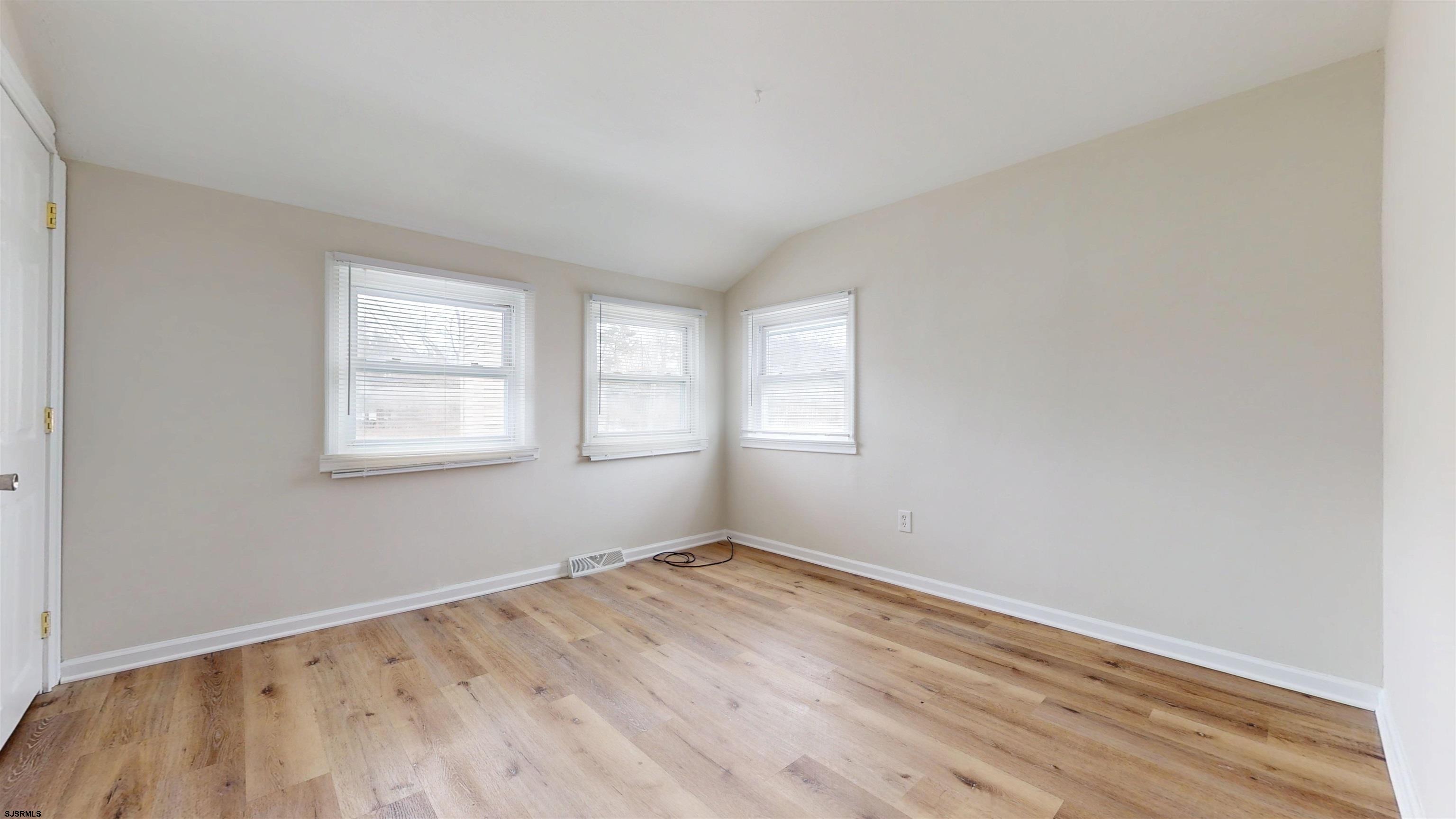 4 East Mill Road Northfield, NJ 08225 - Photo 31 of 49 an empty room with wooden floor and windows