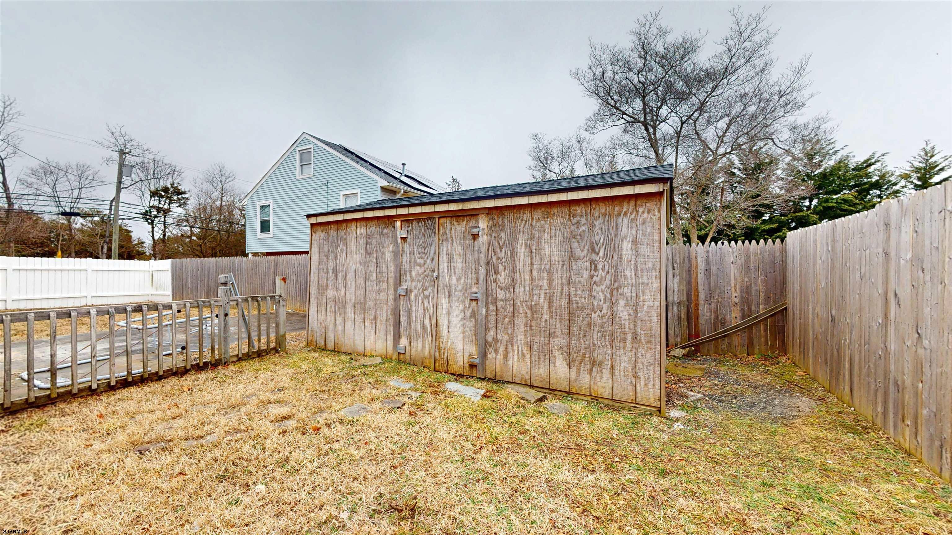 4 East Mill Road Northfield, NJ 08225 - Photo 37 of 49 a view of backyard with small cabin and wooden fence