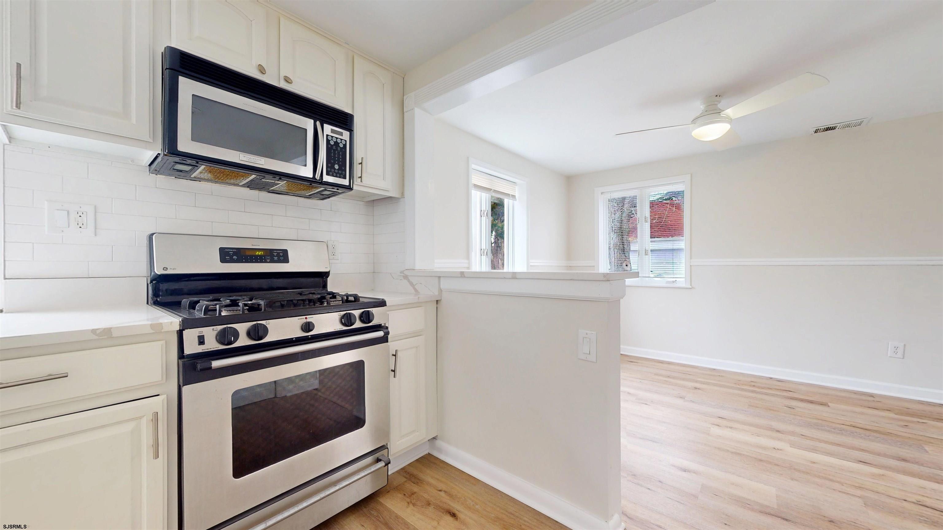 4 East Mill Road Northfield, NJ 08225 - Photo 6 of 49 a kitchen with cabinets wooden floor and stainless steel appliances