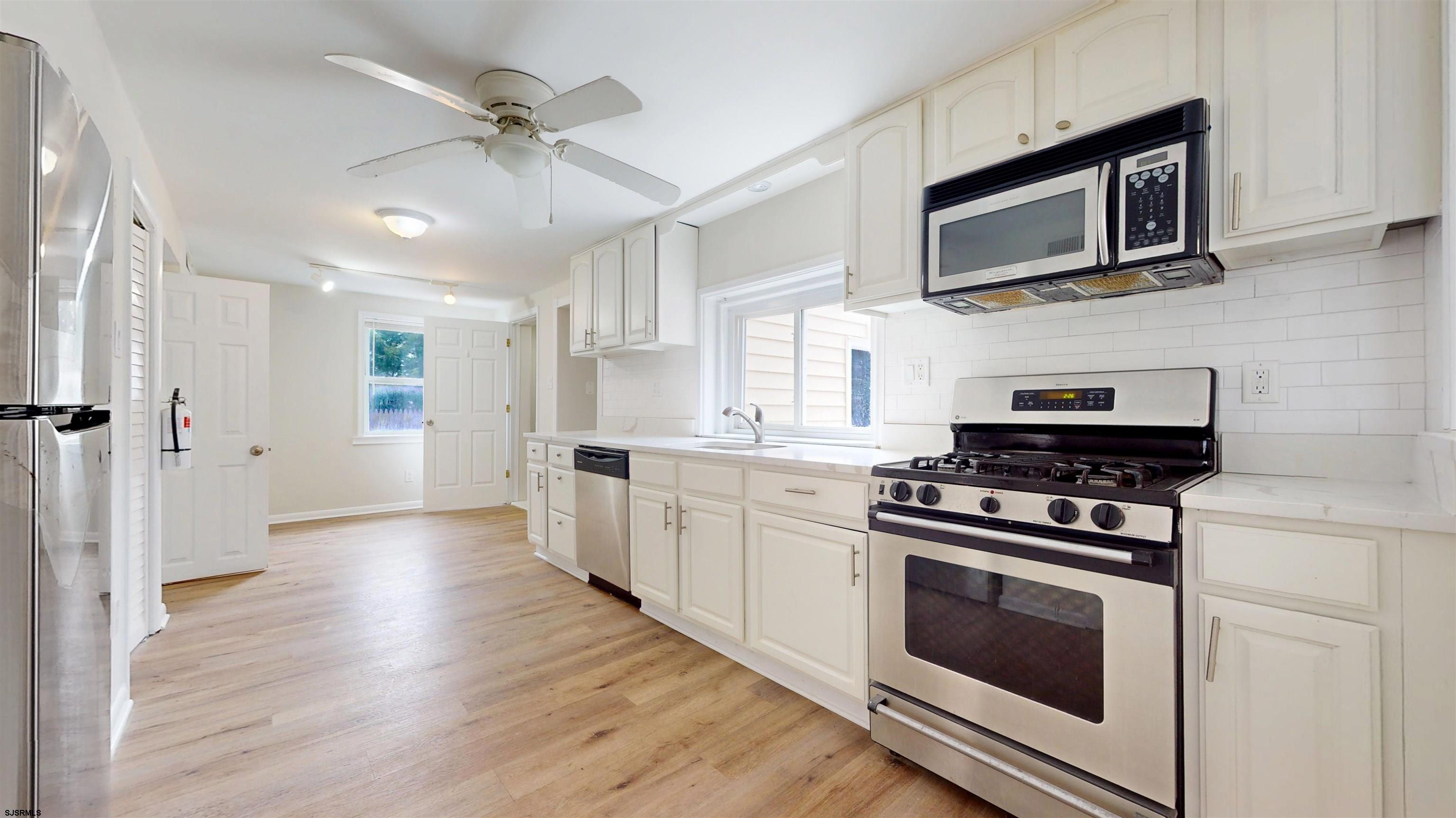 4 East Mill Road Northfield, NJ 08225 - Photo 7 of 49 a kitchen with stainless steel appliances a stove microwave and refrigerator