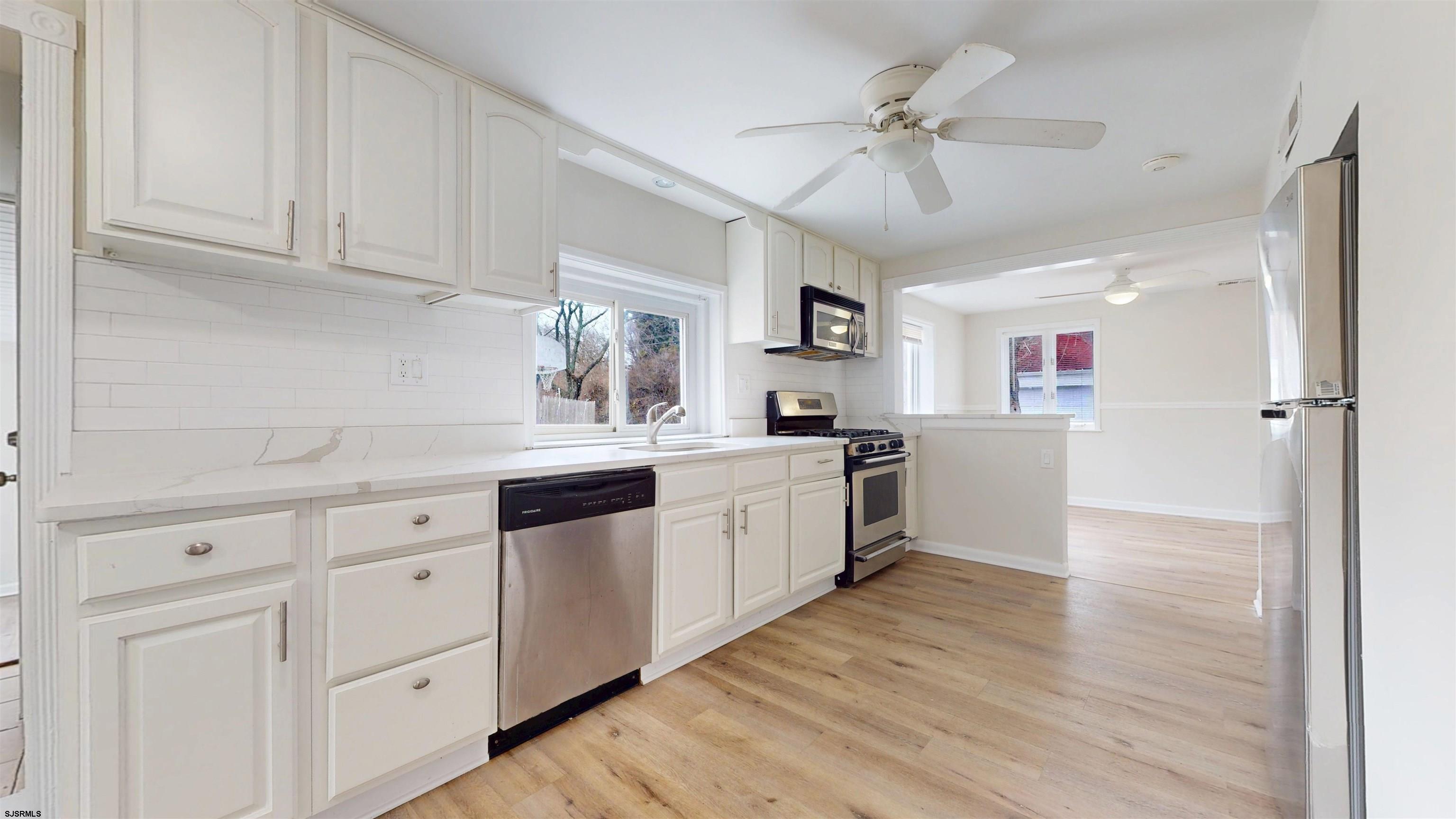 4 East Mill Road Northfield, NJ 08225 - Photo 9 of 49 a kitchen with granite countertop white cabinets and white appliances