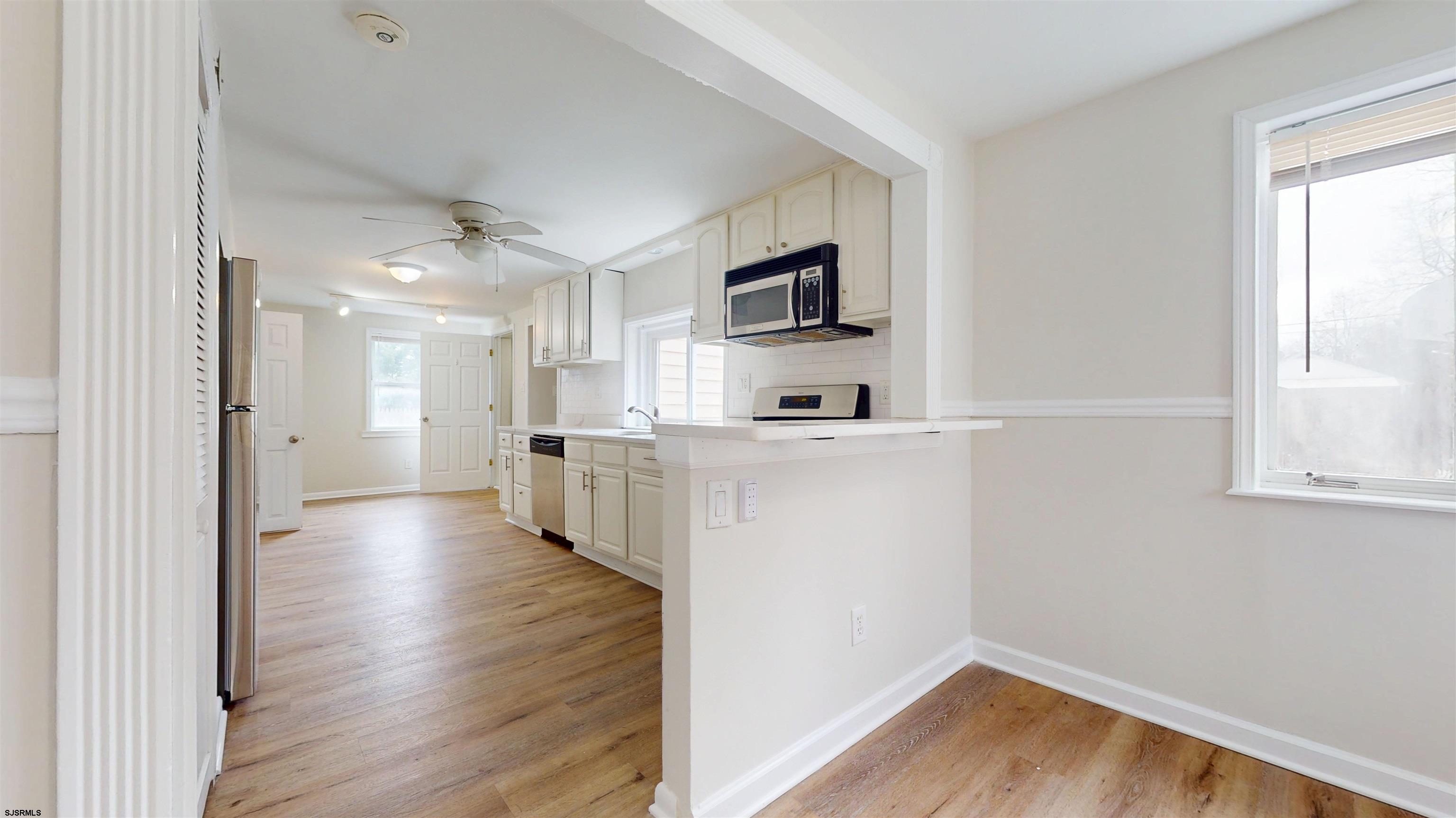 4 East Mill Road Northfield, NJ 08225 - Photo 10 of 49 a view of a kitchen with wooden floor and a window
