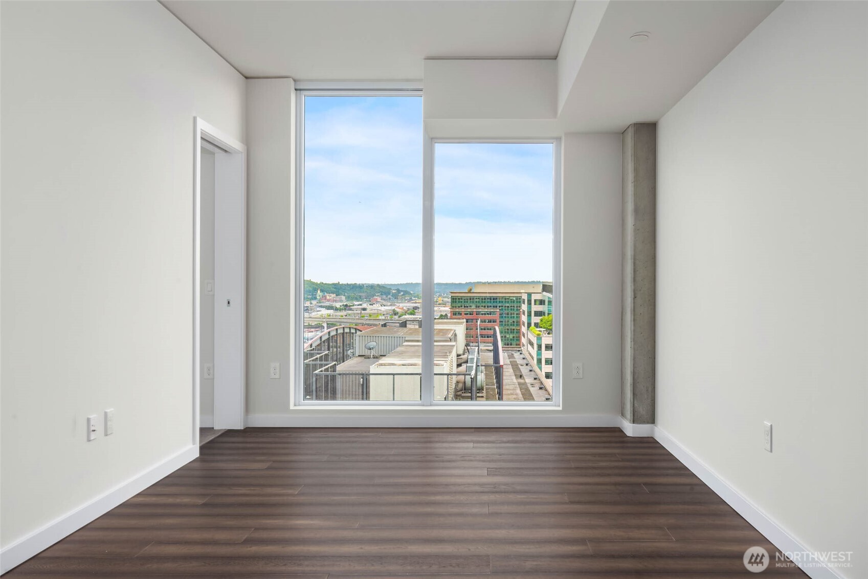 450 South Main Street, Unit 1405 Seattle, WA 98104 - Photo 12 of 38 an empty room with wooden floor and windows